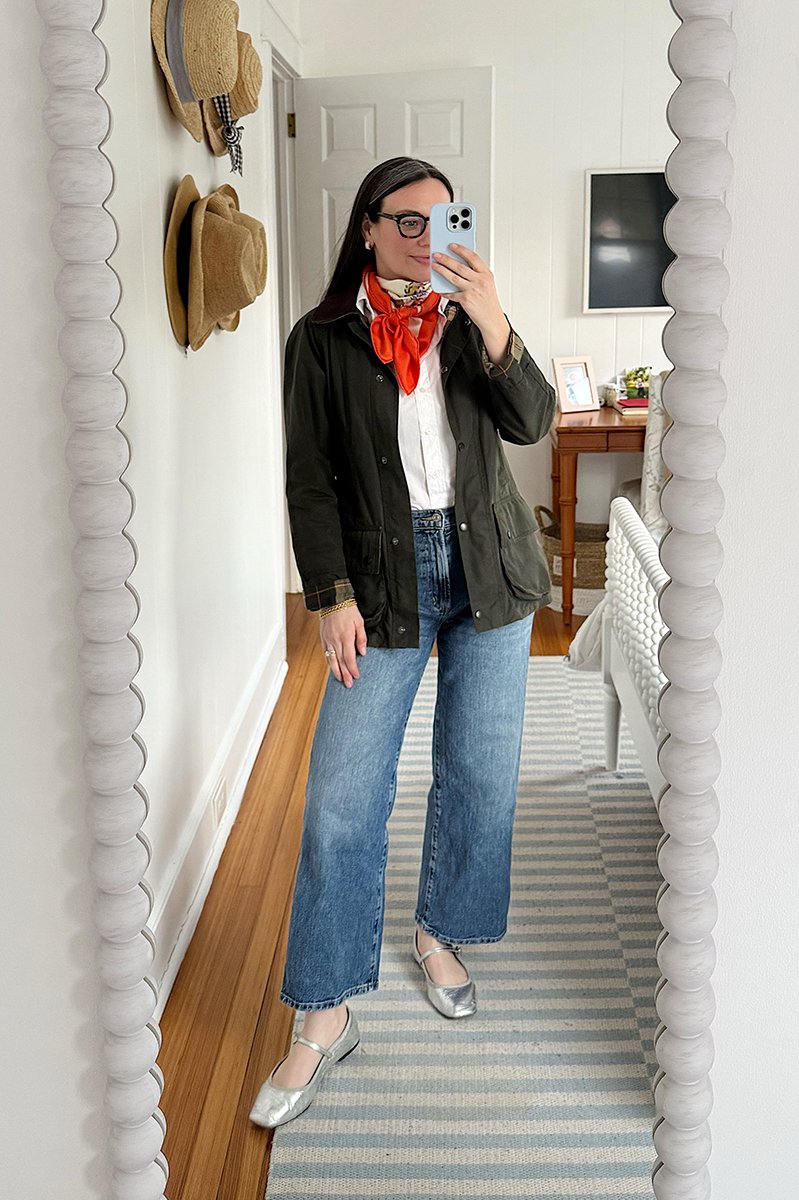 Carly Riordan taking a mirror selfie wearing a Barbour jacket and Hermes scarf.